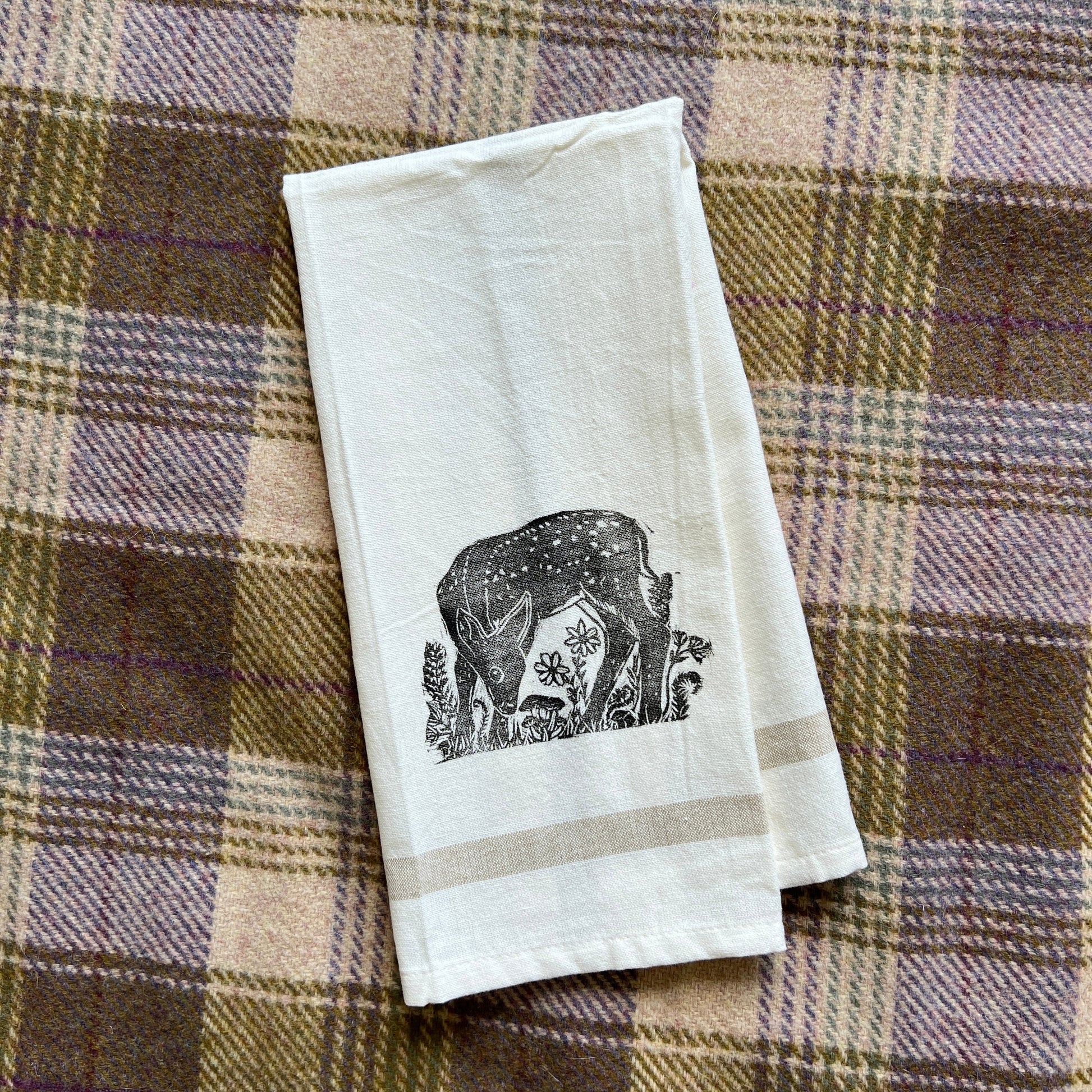White kitchen towel with a stamped fawn in black ink