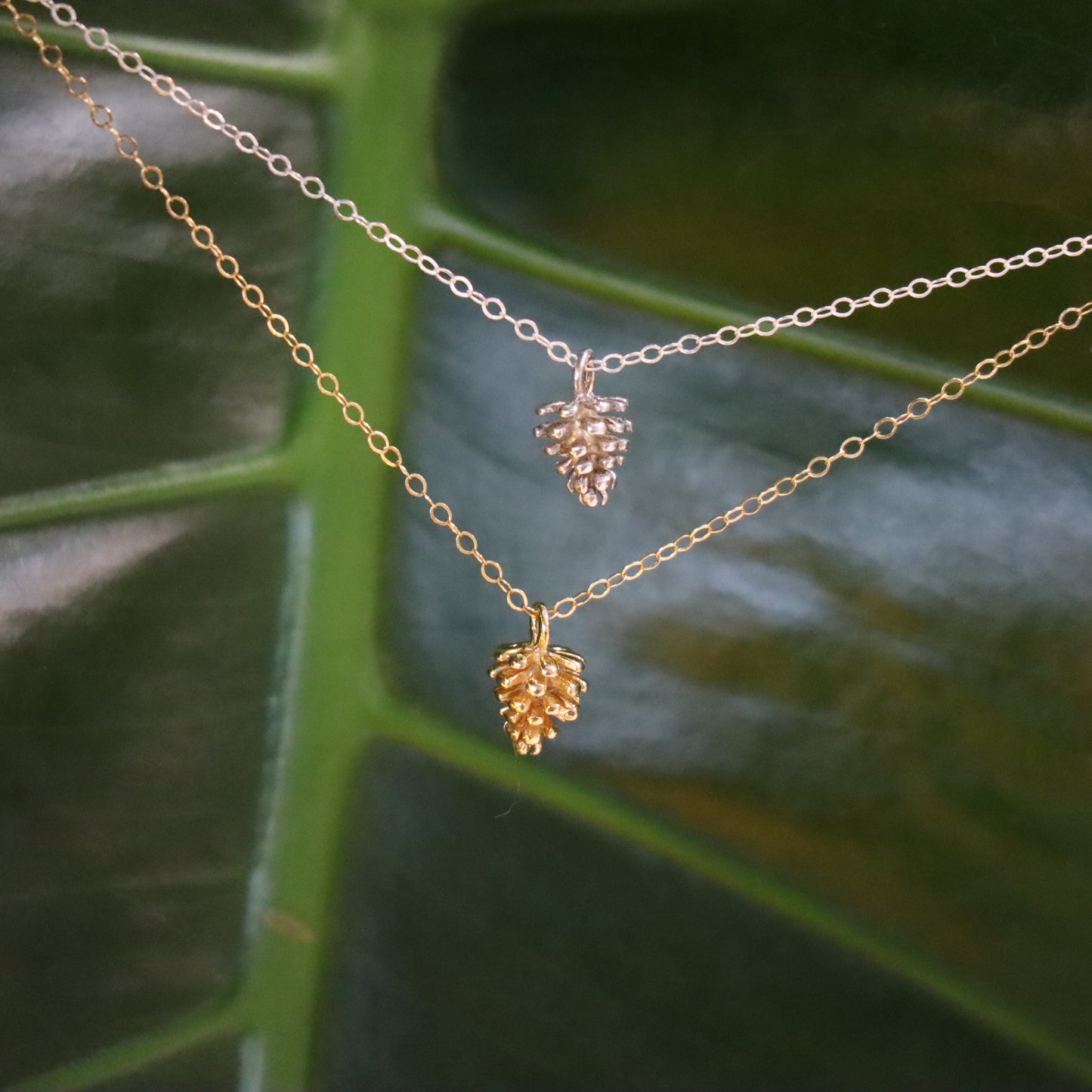 one silver and one gold pinecone charm necklace